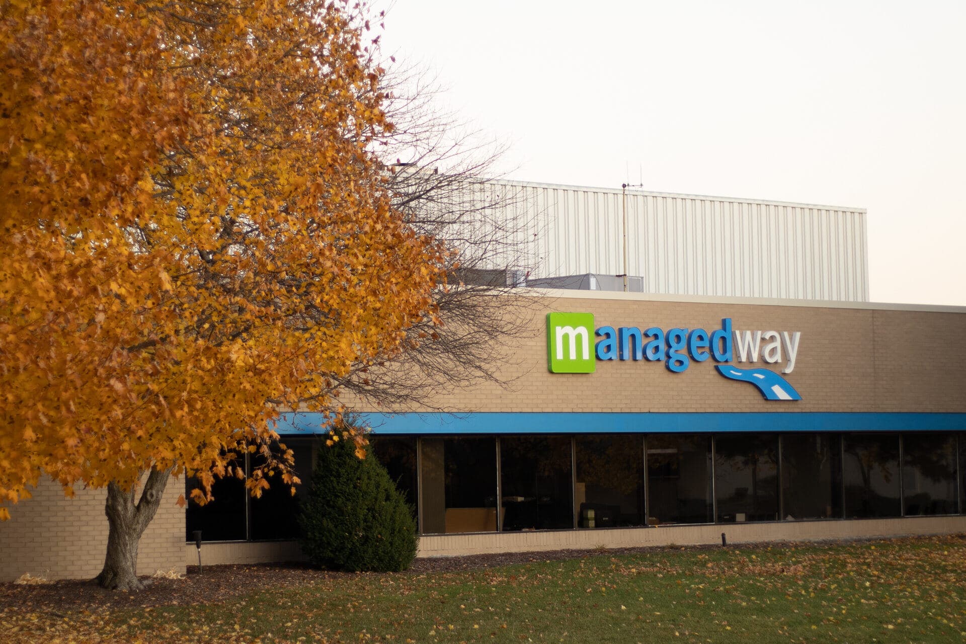 The front of ManagedWay's headquarters at 600 Executive Drive in Troy, Michigan. Autumn day, brand wordmark on the fascia.